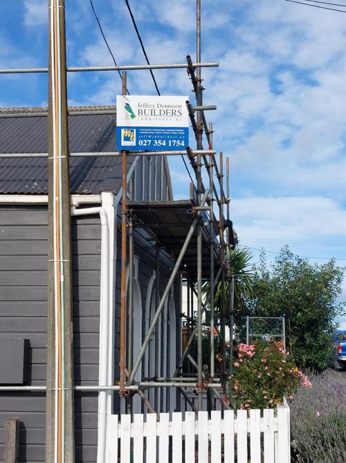 Pratt St Waikouaiti Close up of scaffolding and JDBuilders sign with old roofing in the background JDBuilders 8