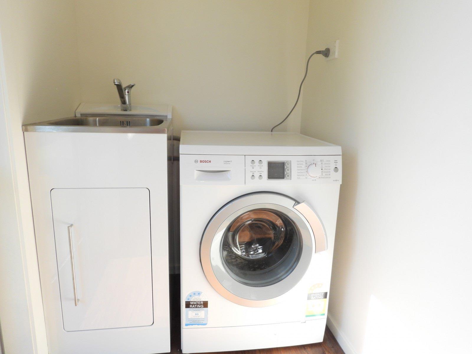 6 66 Norwich St, Hampden Close up of the renovated laundry with new appliances washing machine and dryer JDBuilders