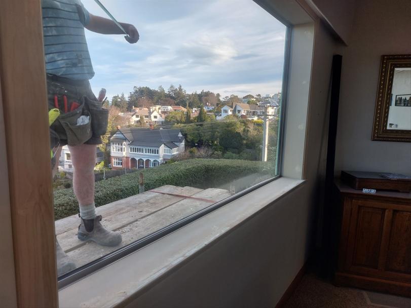 7 19 Tweed St Roslyn, Dunedin Newly installed double glazed window in the loungeroom being stopped and sanded in the interior, with the exterior flashings being measured JDBuilders