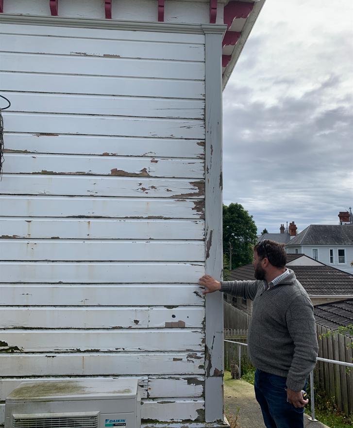 B7 9 Fifield St, Roslyn, Dunedin Jeff inspecting rotten weatherboards at the back of the house, before renovation JDBuilders